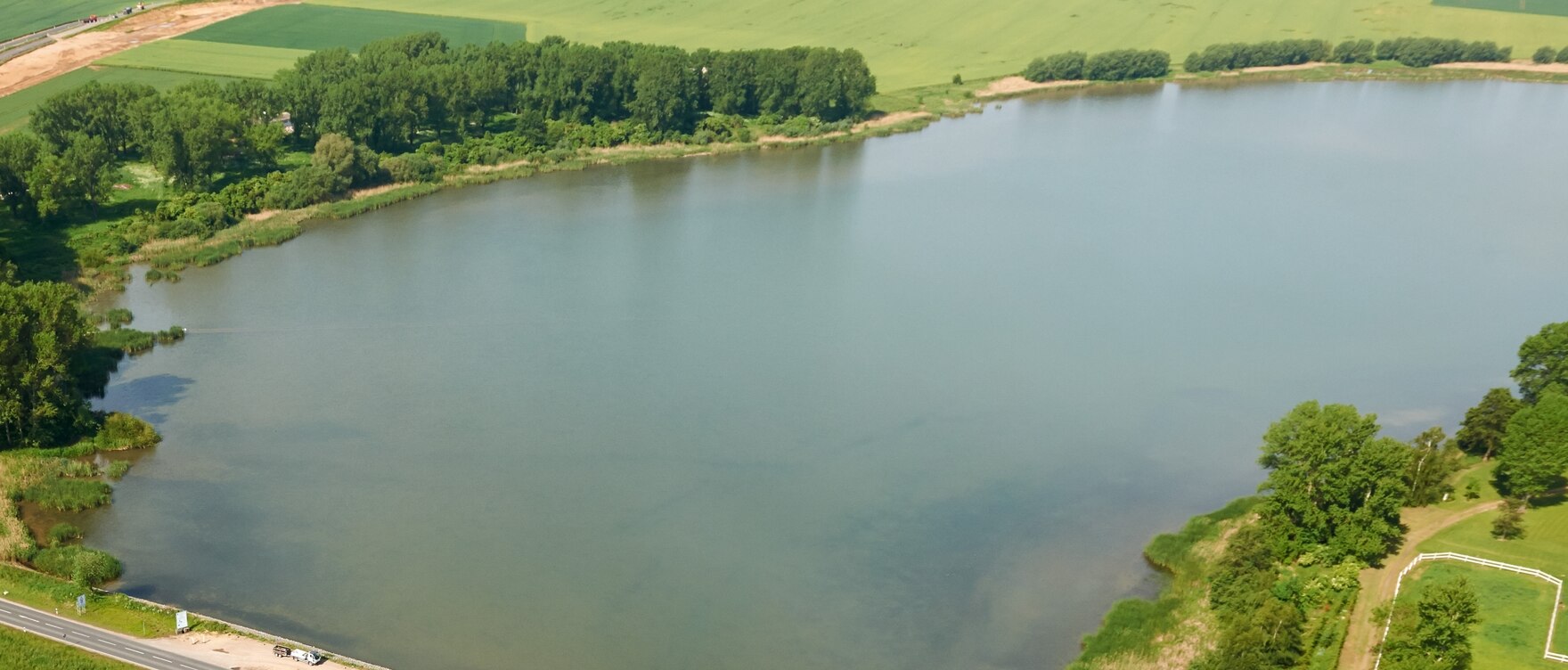 Luftbild einer Talsperre, an der eine Straße vorbei führt