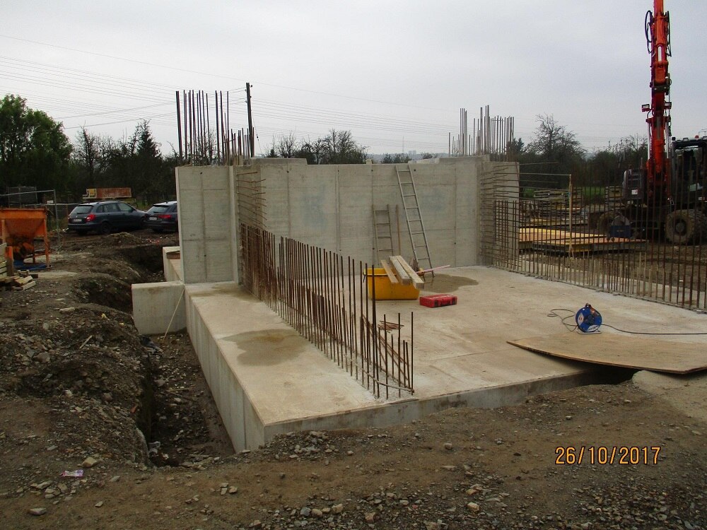 Blick auf Baustelle mit großem Betonfläche und Mauern und Stahl, der heraussteht